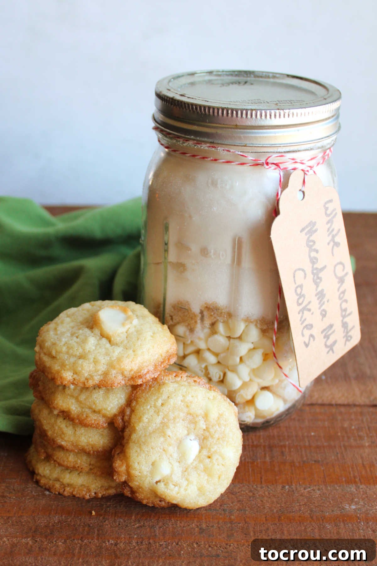 Buttery  homemade white chocolate macadamia nut cookies next to a jar of homemade mix. 