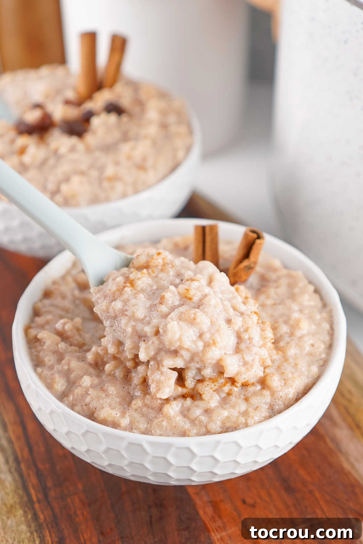 Quick-Fix Creamy Crockpot Rice Pudding 4 Bite of creamy crockpot rice pudding on a spoon, ready to eat.