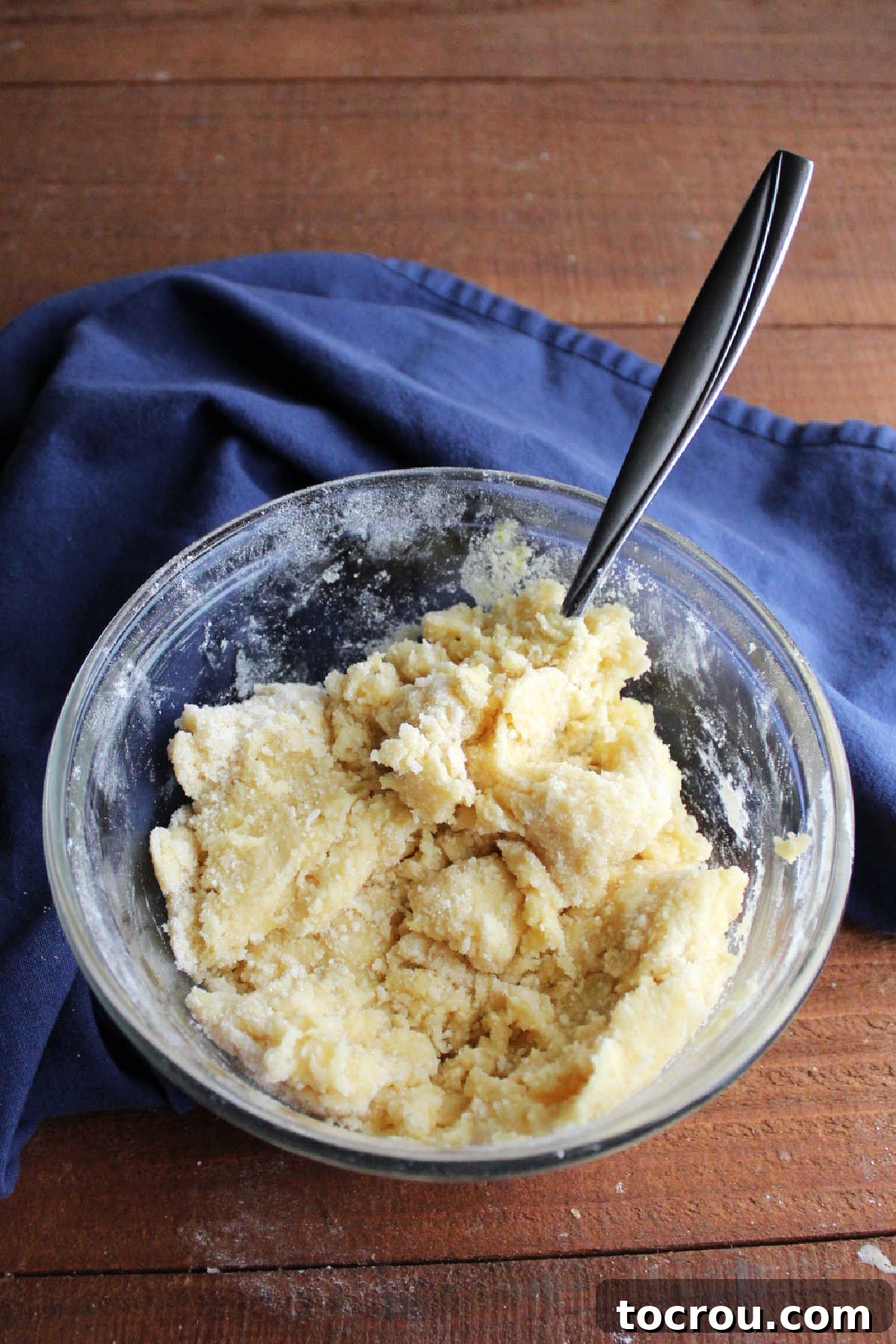 Egg stirred into flour mixture to make a crumbly dough