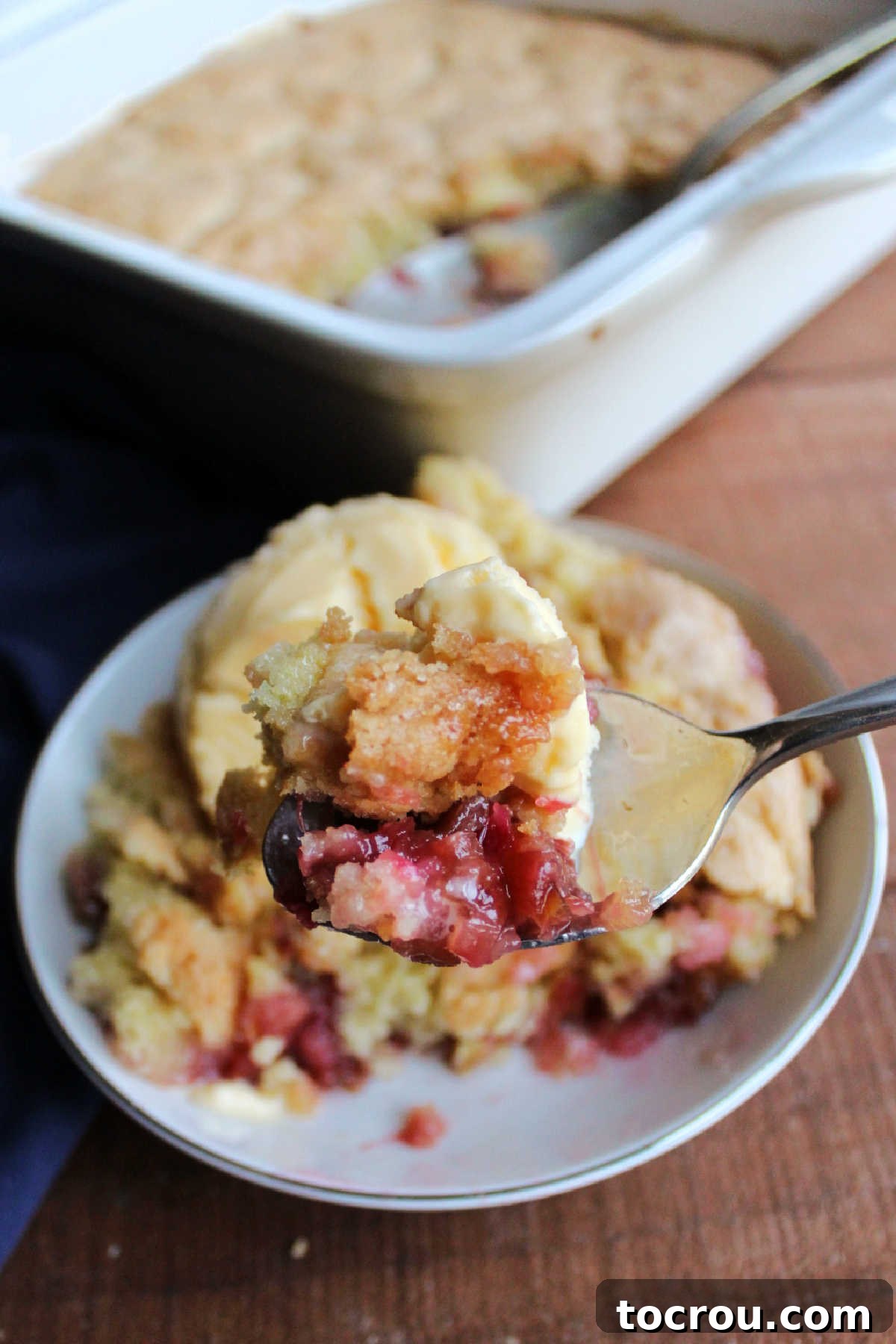 Bite of rhubarb cobbler on spoon with a little bit of vanilla ice cream. 