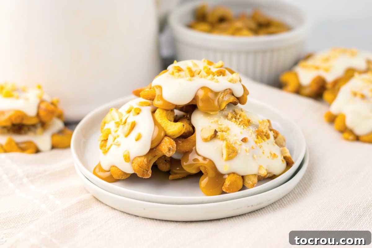 Plate piled with homemade caramel cashew clusters topped with white chocolate and chopped cashews. 