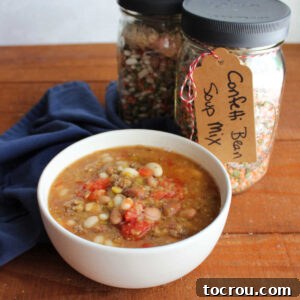 Bowl of confetti bean soup next to a couple of jars of homemade bean soup mix.