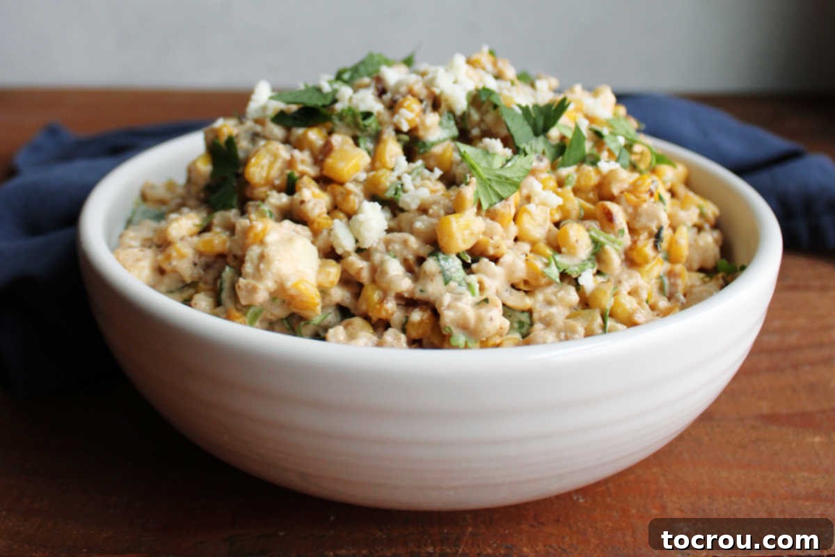 Mexican Street Corn Barley Salad A vibrant bowl of Mexican Street Corn Barley Salad, featuring fluffy barley, charred corn kernels, crumbled queso fresco, and fresh cilantro, all coated in a creamy, zesty dressing.