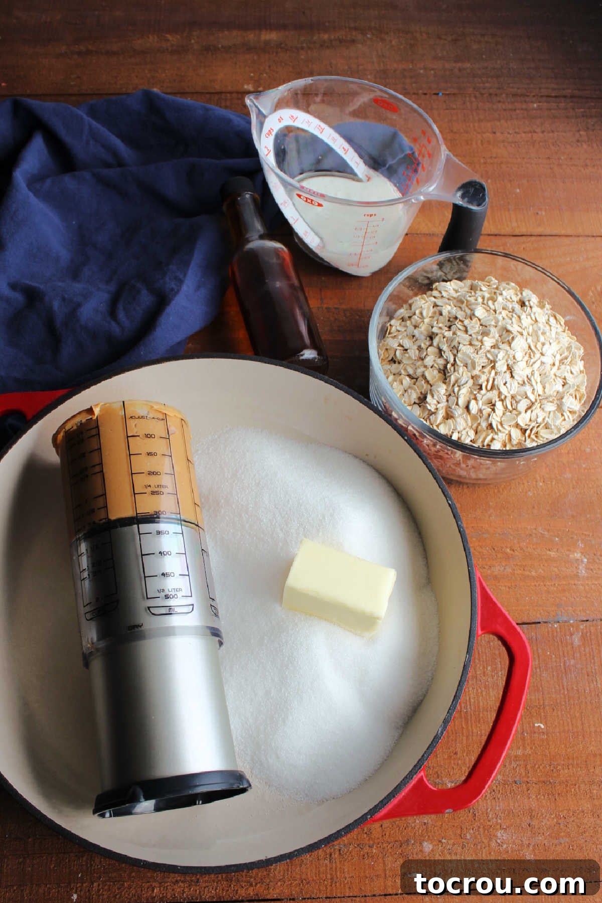 Gathered ingredients for no-bake cookies: creamy peanut butter, granulated sugar, softened butter, fresh milk, and hearty old-fashioned oats.