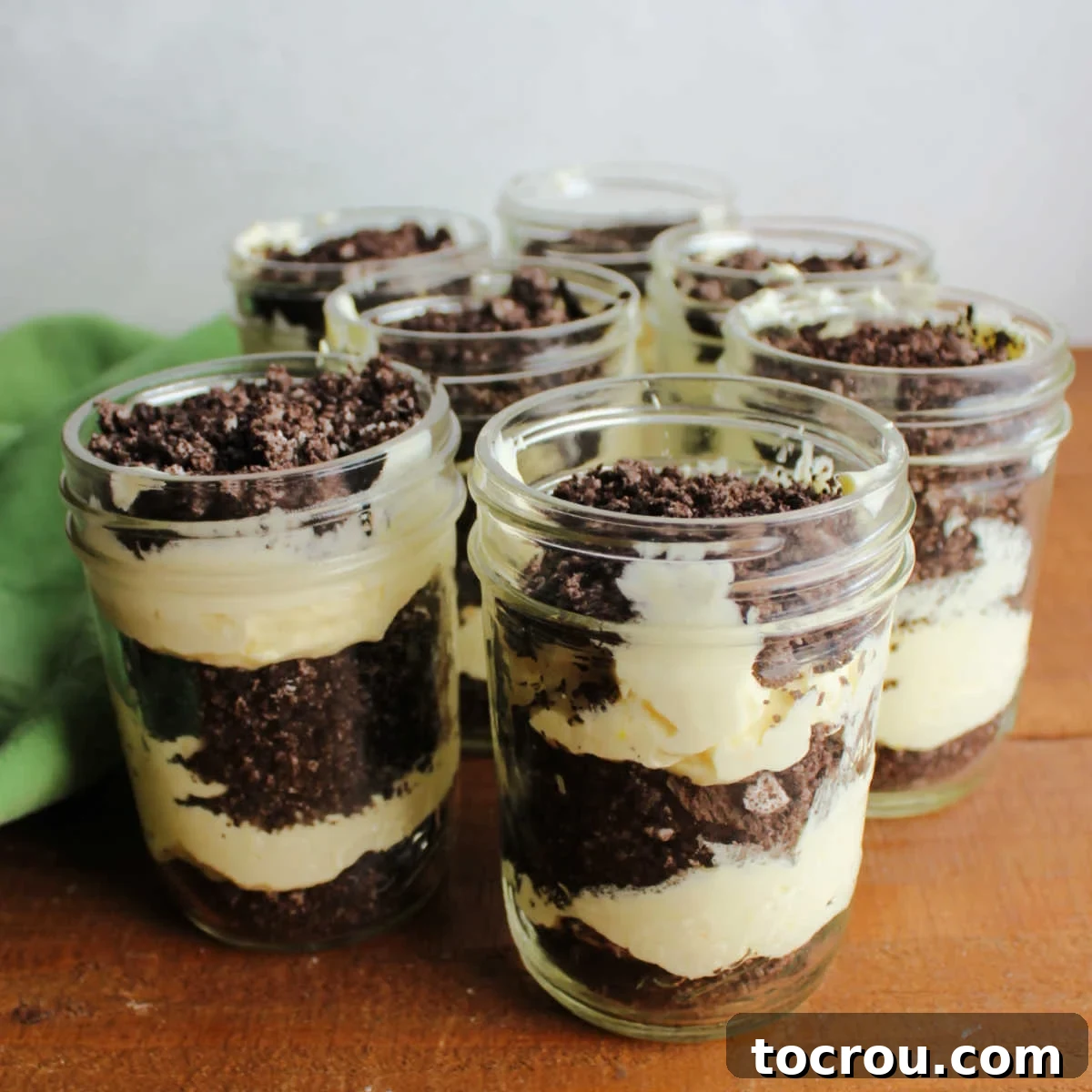 Dirt Pudding Jars with Oreo Crumbs Layers of vanilla pudding mixture and chocolate oreo crumbs layered in jars to make dirt pudding.
