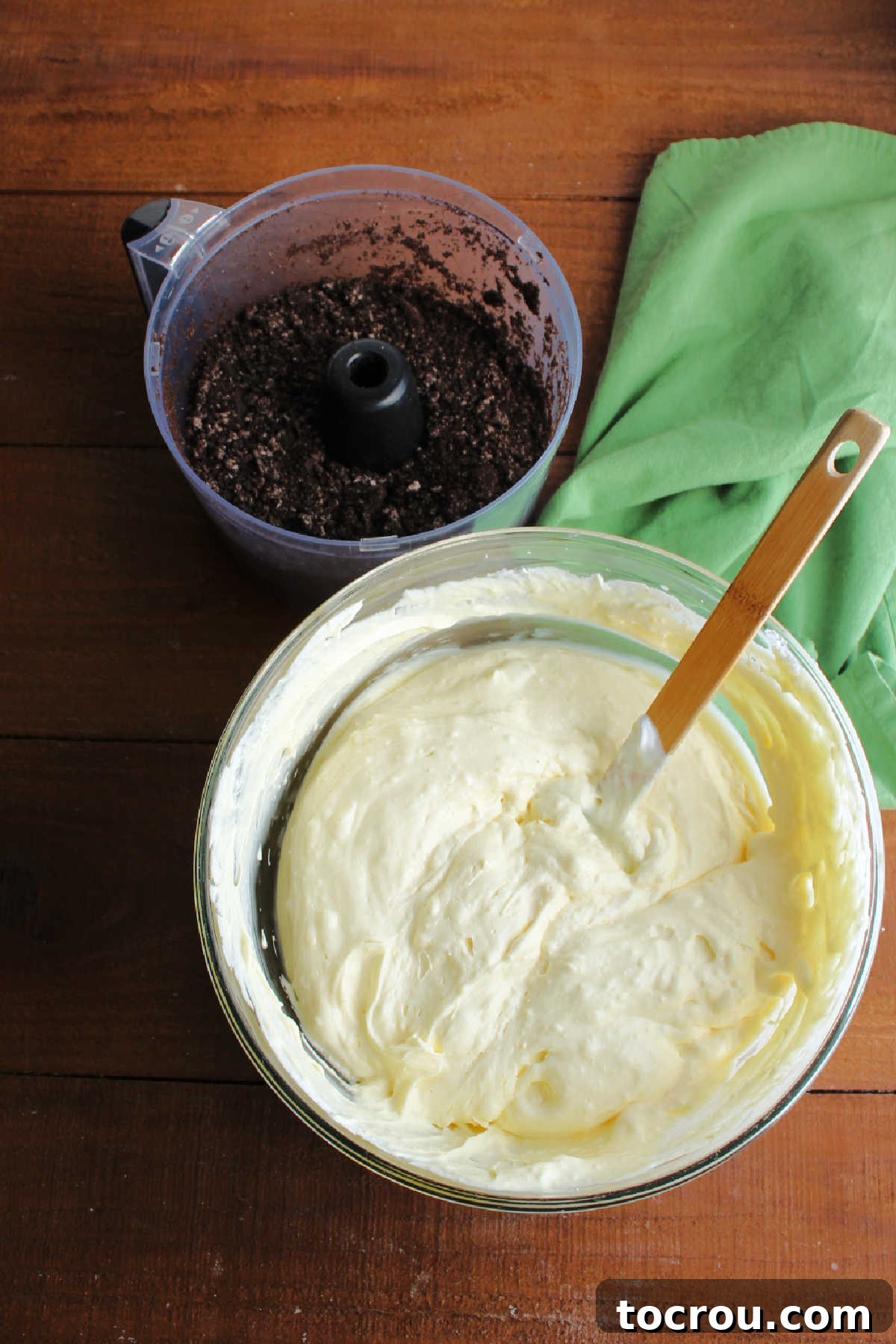 Crushed Oreos and Pudding Mixture Bowl of prepared vanilla pudding mixture and chocolate cookie crumbs in food processor ready to be layered into dirt pudding.