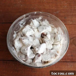 Chunks of venison roast coated in seasoned flour, ready to be made into stew.