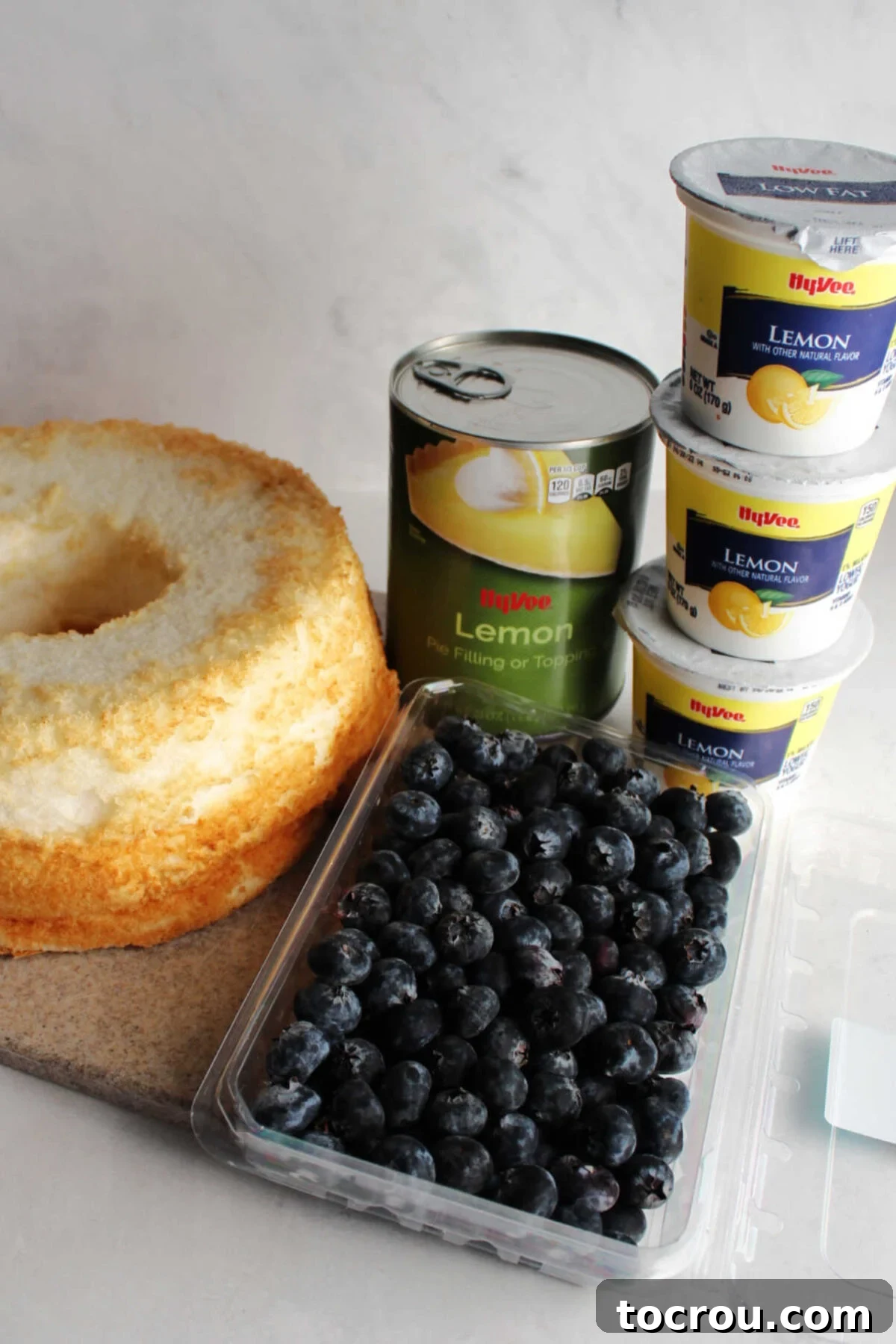 Zesty Lemon Blueberry Parfaits 2 Ingredients for lemon blueberry parfaits: angel food cake, fresh blueberries, canned lemon pie filling, and lemon yogurt ready for assembly.