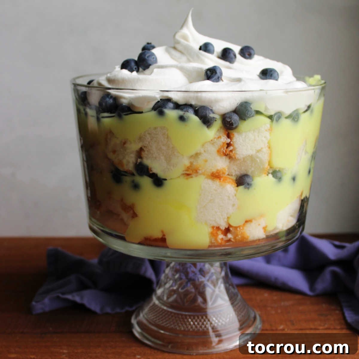 Zesty Lemon Blueberry Parfaits 4 Antique trifle bowl filled with layers of angel food cake, lemon filling and fresh blueberries, ready to serve at a spring gathering.