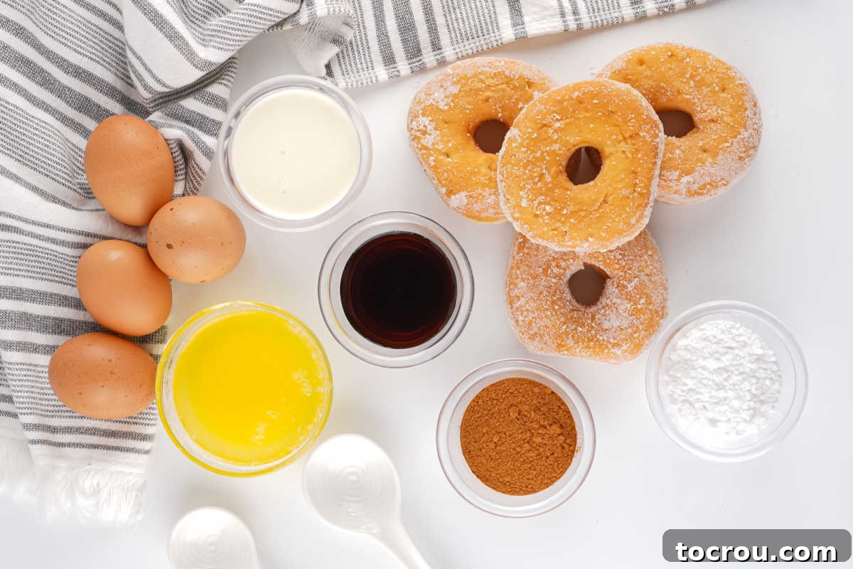 A close-up of ingredients for donut bread pudding, including stale donuts, whole milk, large eggs, melted butter, ground cinnamon, vanilla extract, and powdered sugar, all arranged on a counter.