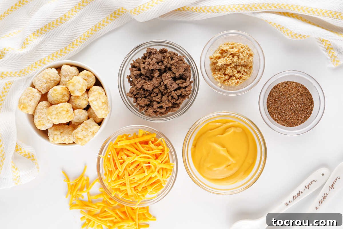 Ingredients including tater tots, ground beef, taco seasoning cheese sauce, shredded cheese and minced onion ready to be made into a crockpot tater tot casserole. 