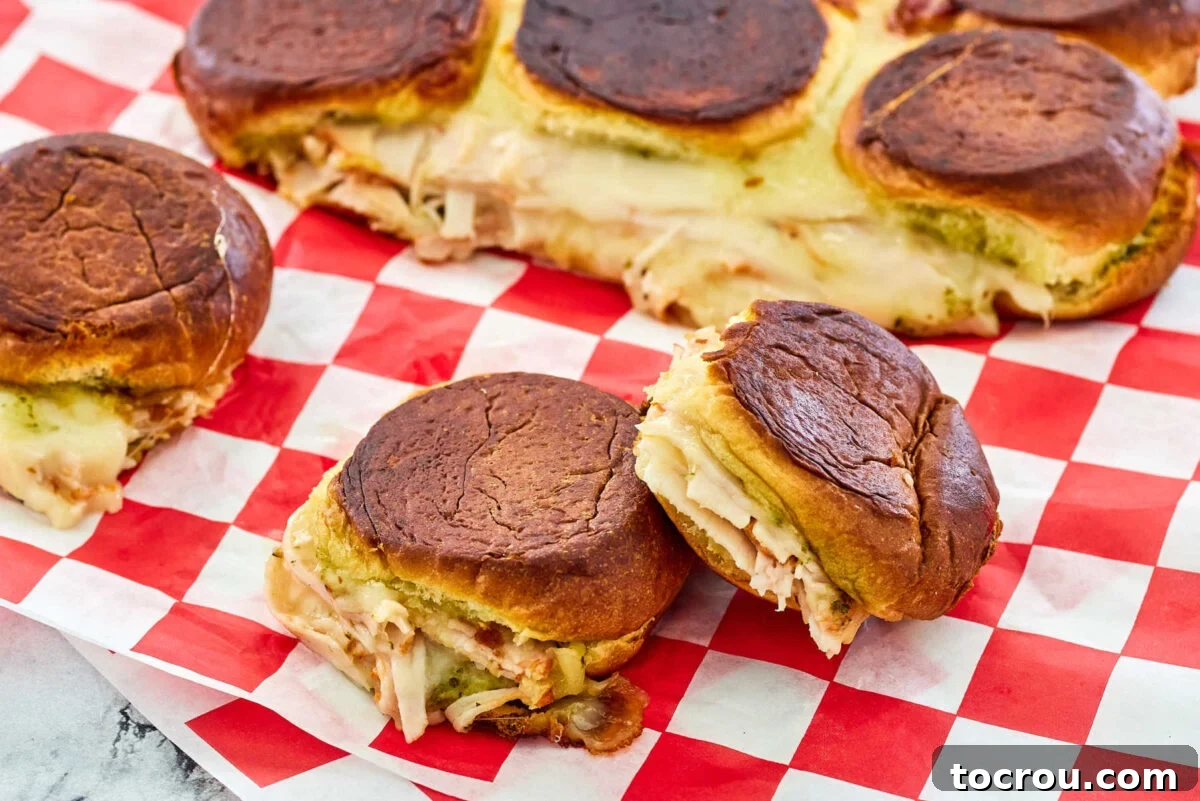 Delicious turkey grilled cheese sliders featuring vibrant pesto and sweet craisins, offering a perfect blend of flavors and textures.