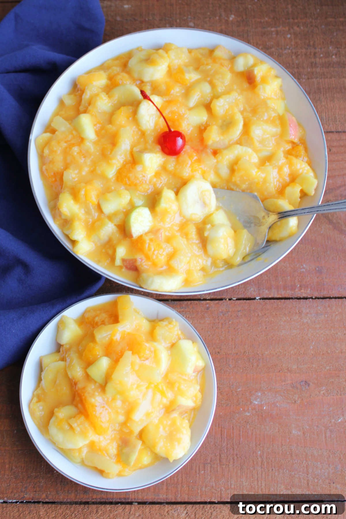 Zesty Fruit Medley 6 Serving bowl of fruit salad with creamy orange dressing next to a smaller bowl with a serving of Tang fruit salad inside.