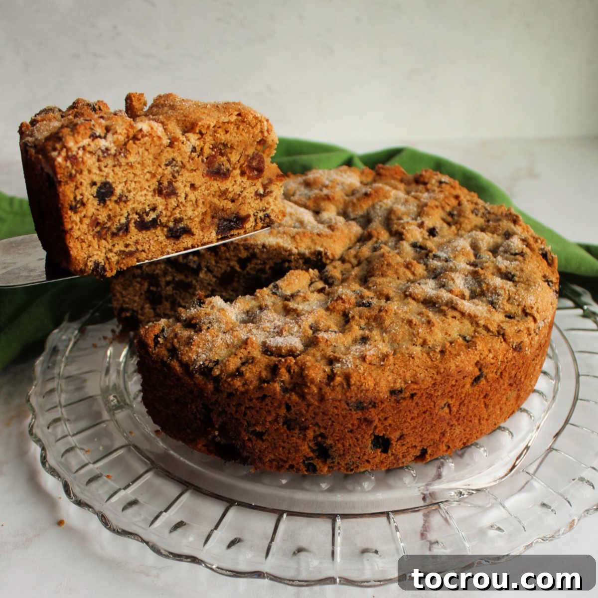 Irish Fruit Tea Loaf 2 First slice of Irish tea brack being lifted out of round cakelike loaf, showing lots of fruit in the interior.