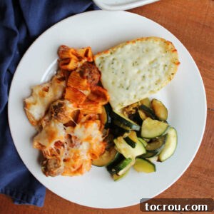 Dinner plate with no boil rigatoni and meatballs, sauteed zucchini and a hunk of cheesy garlic bread. A hearty and satisfying meal.