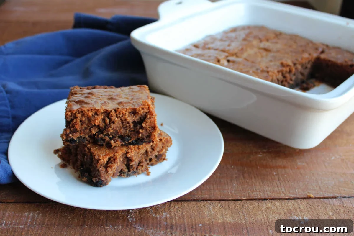 Plate with several pieces of prune brownies next to the pan with more brownies inside, inviting you to take another slice.