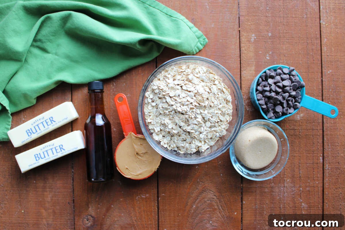Various ingredients laid out, including butter, vanilla extract, creamy peanut butter, rolled oats, light brown sugar, and semisweet chocolate chips, ready for making no-bake cookie bars.