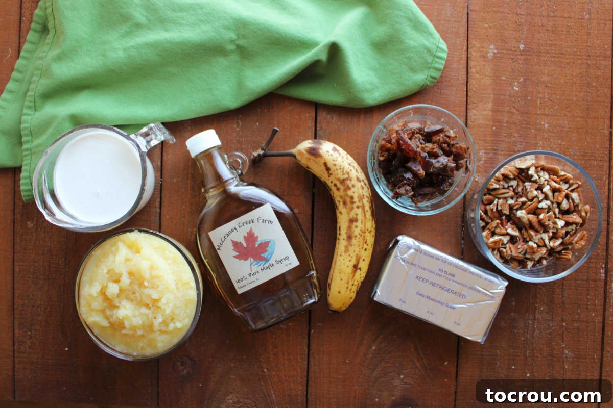 Ingredients including dates, pecans, a banana, crushed pineapple, cream cheese, maple syrup and heavy cream ready to be made into a frozen fruit salad. 