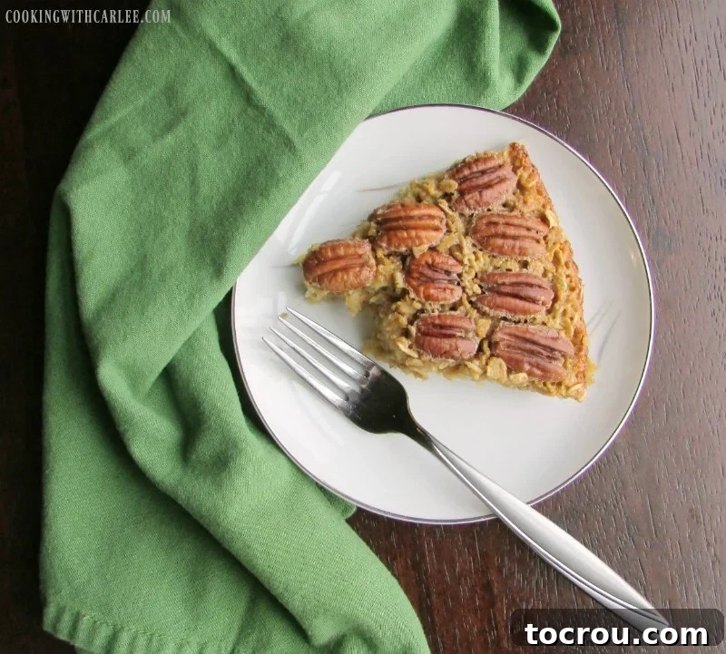 Pecan Pie Baked Oatmeal: A Hearty and Delicious Breakfast Transformation A slice of pecan pie baked oatmeal with a couple of bites taken, showcasing the rich texture and pecan topping.