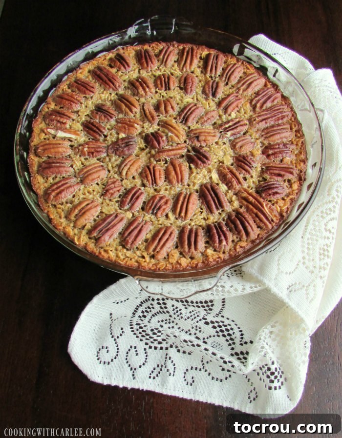 Pecan Pie Baked Oatmeal: Wholesome Indulgence for Any Morning A baking dish of pecan pie baked oatmeal, with whole pecans artfully arranged on top, ready for the oven.