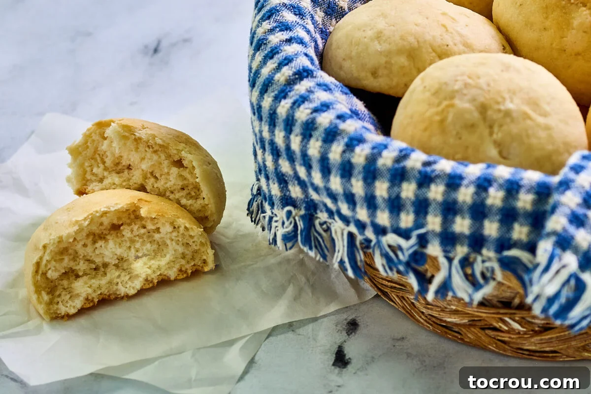 Potato roll broken in half, showing soft center and buttery golden brown top.