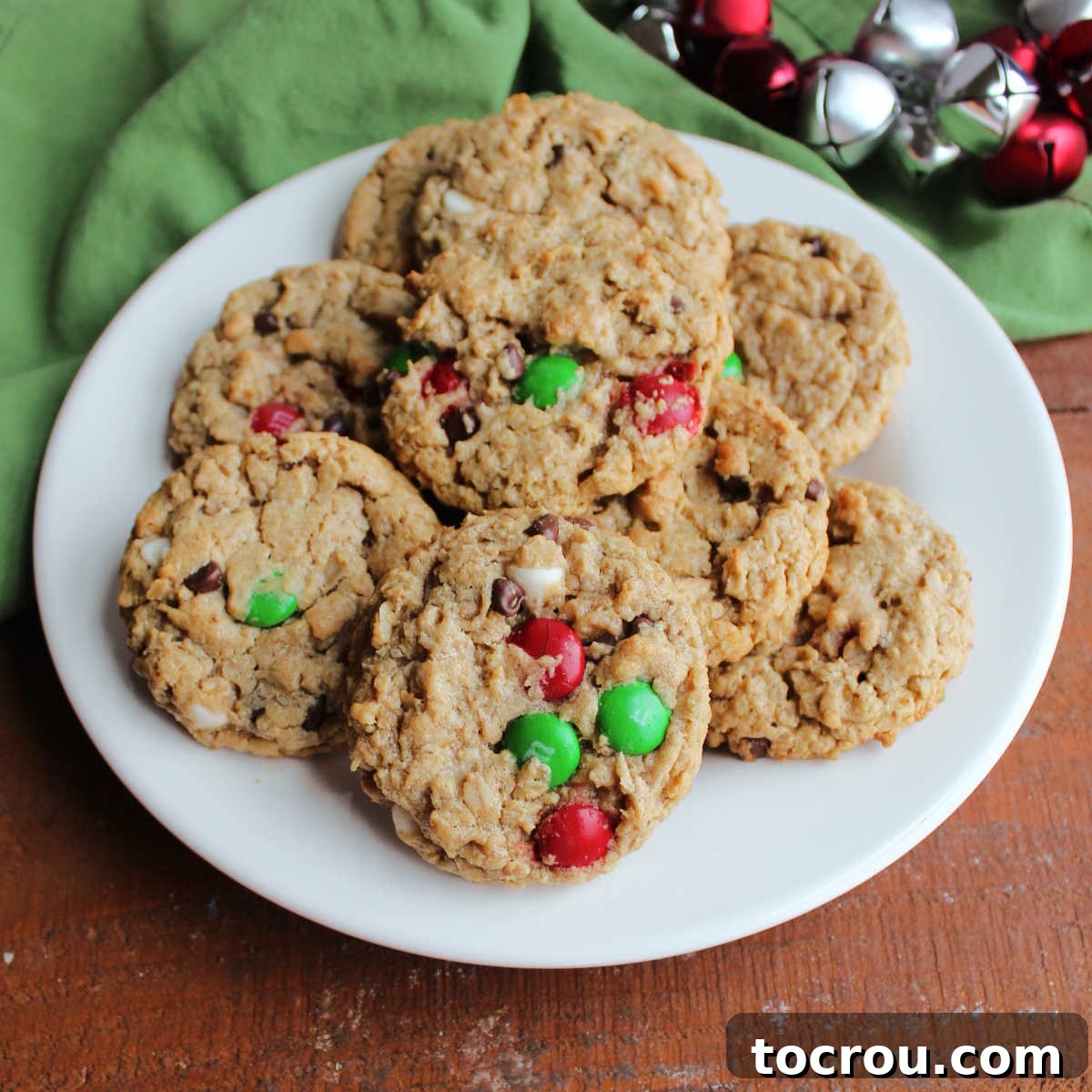 Irresistible Peanut Butter Oatmeal Monster Cookies Plate of freshly baked peanut butter oatmeal monster cookies with holiday colored M&Ms, ready to eat.