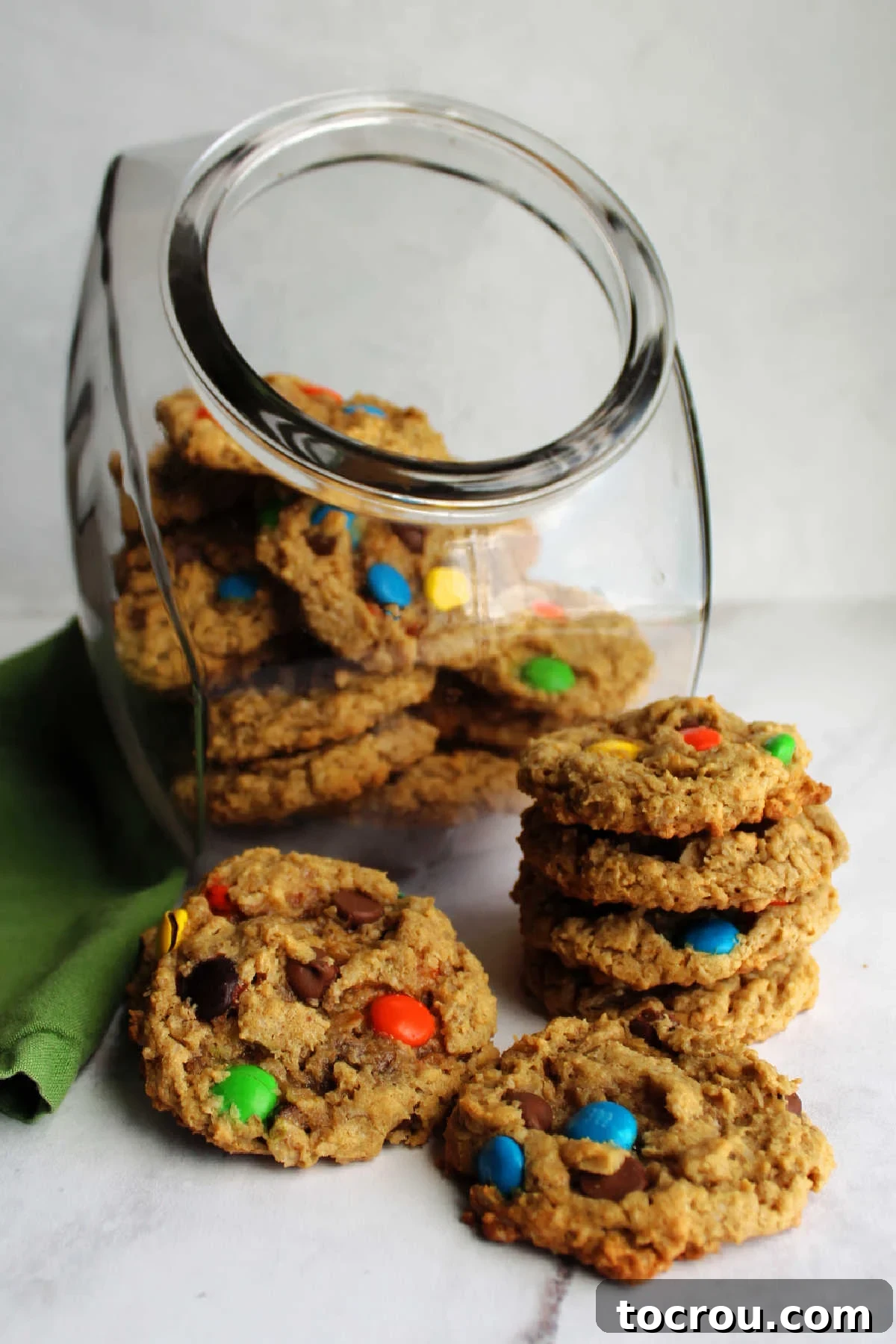 Monster Cookies Ready to Share Stack of monster cookies in front of cookie jar filled with more.