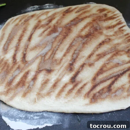 Soft potato dough rolled out into a square shape topped with melted butter and cinnamon sugar.