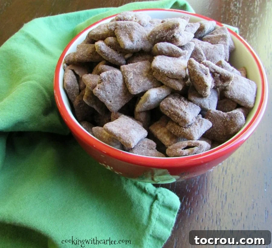 An overhead shot showcasing a large batch of homemade brownie batter muddy buddies, with each piece glistening from its rich, chocolatey coating.