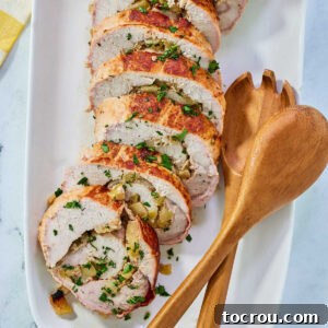 Apple Stuffed Pork Loin Slices Slices of pork loin rolled around an apple and rosemary filling on serving platter.