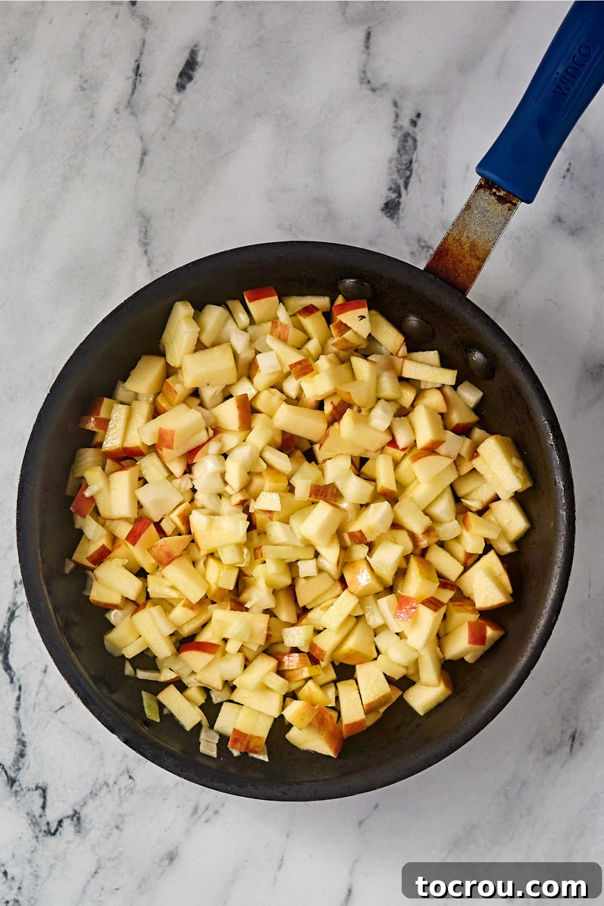 Sautéing Apples and Onions Skillet with chopped onions and apples, ready to be cooked.