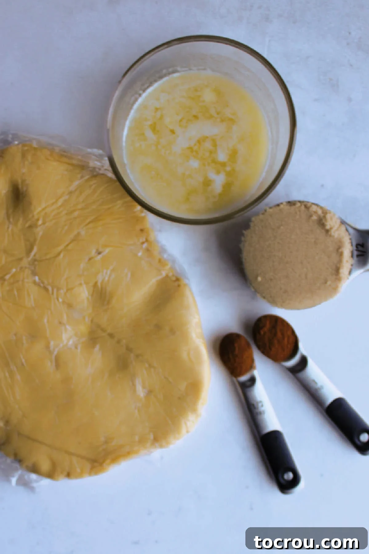 Chilled sugar cookie dough next to melted butter, brown sugar and cinnamon for the filling.