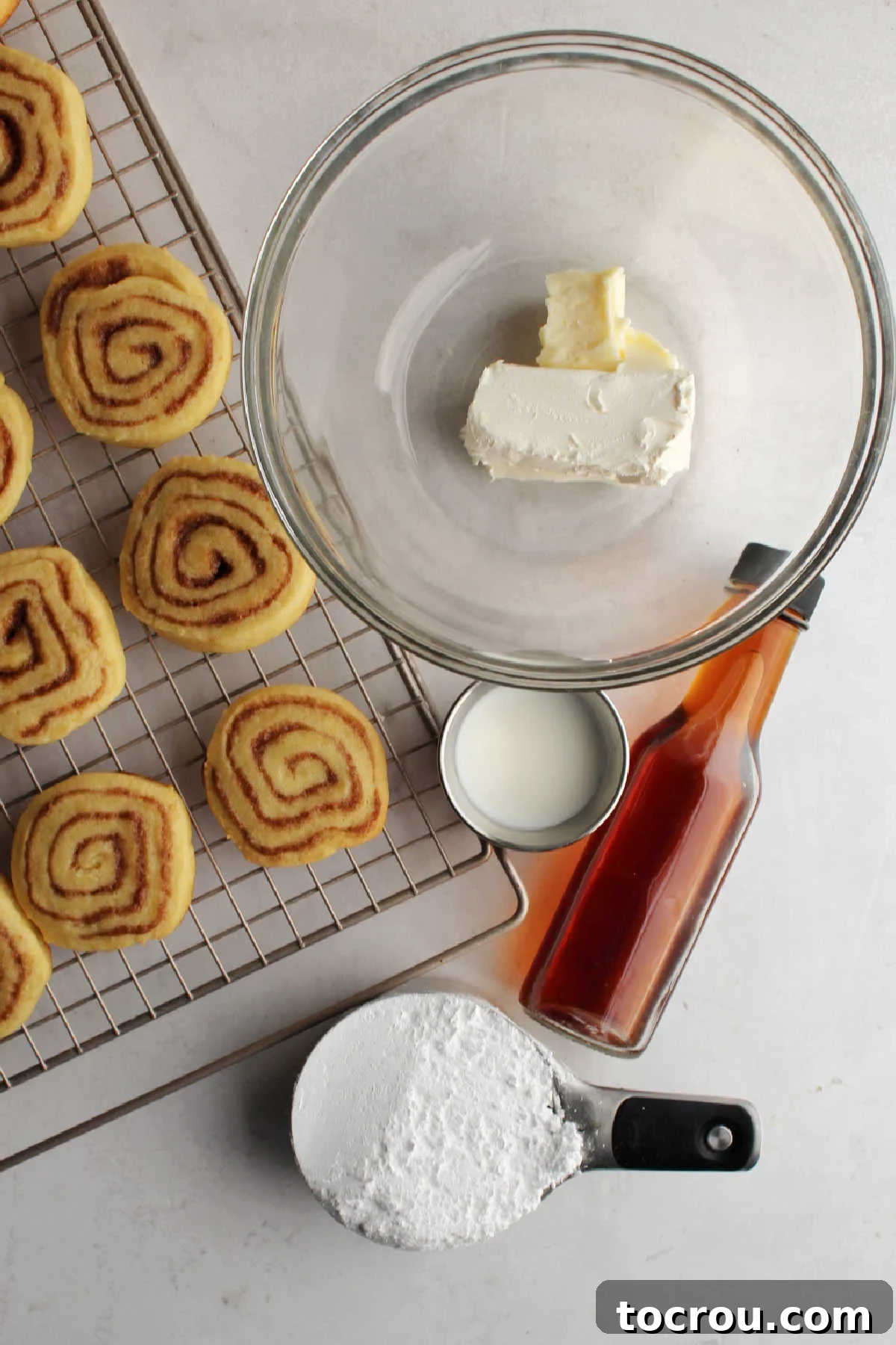 Cream cheese icing ingredients next to cooling cookies.