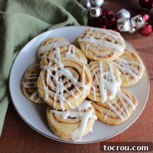 Plate of cinnamon roll cookies topped with cream cheese icing.