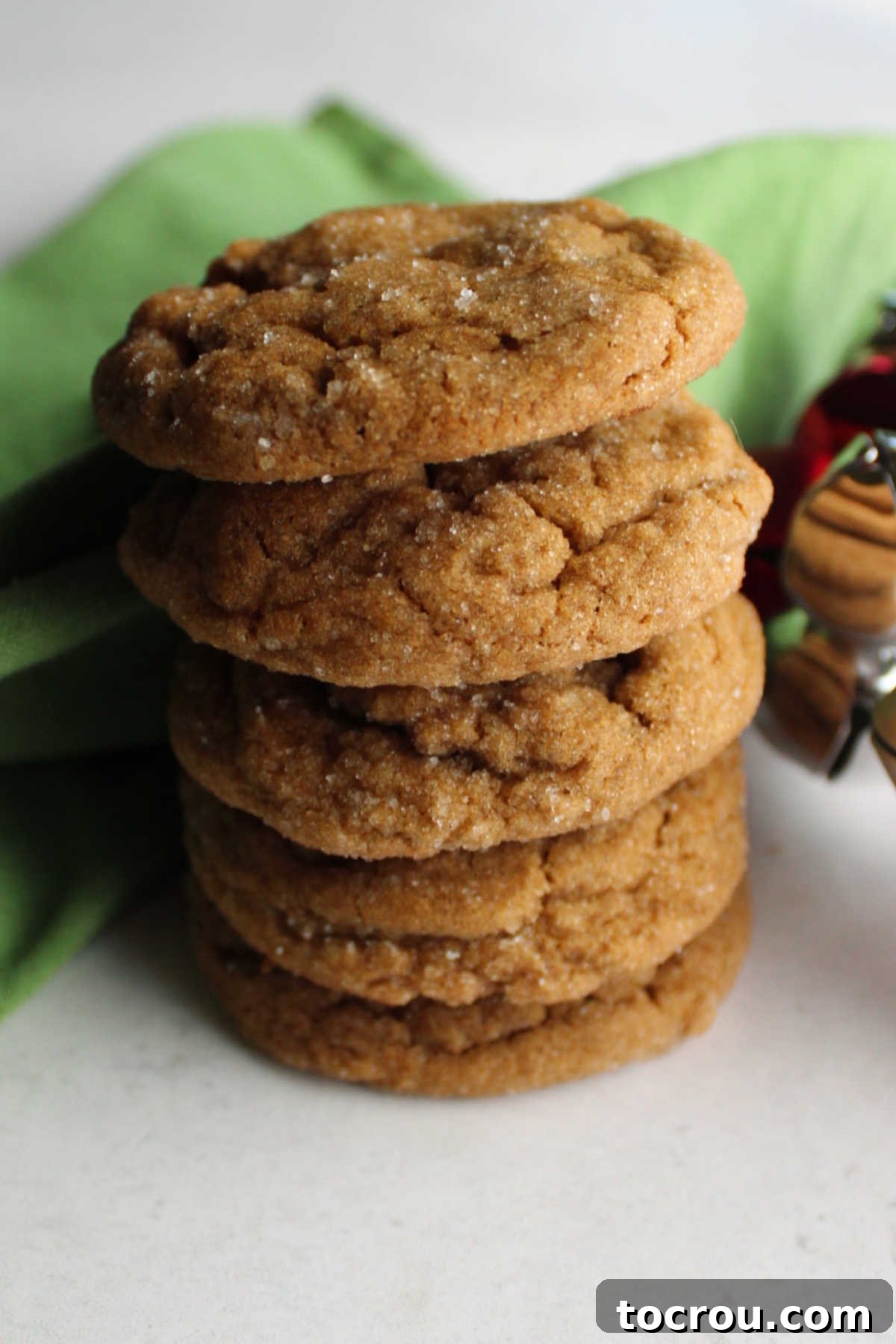 Stack of crinkly looking ginger molasses cookies ready to eat.