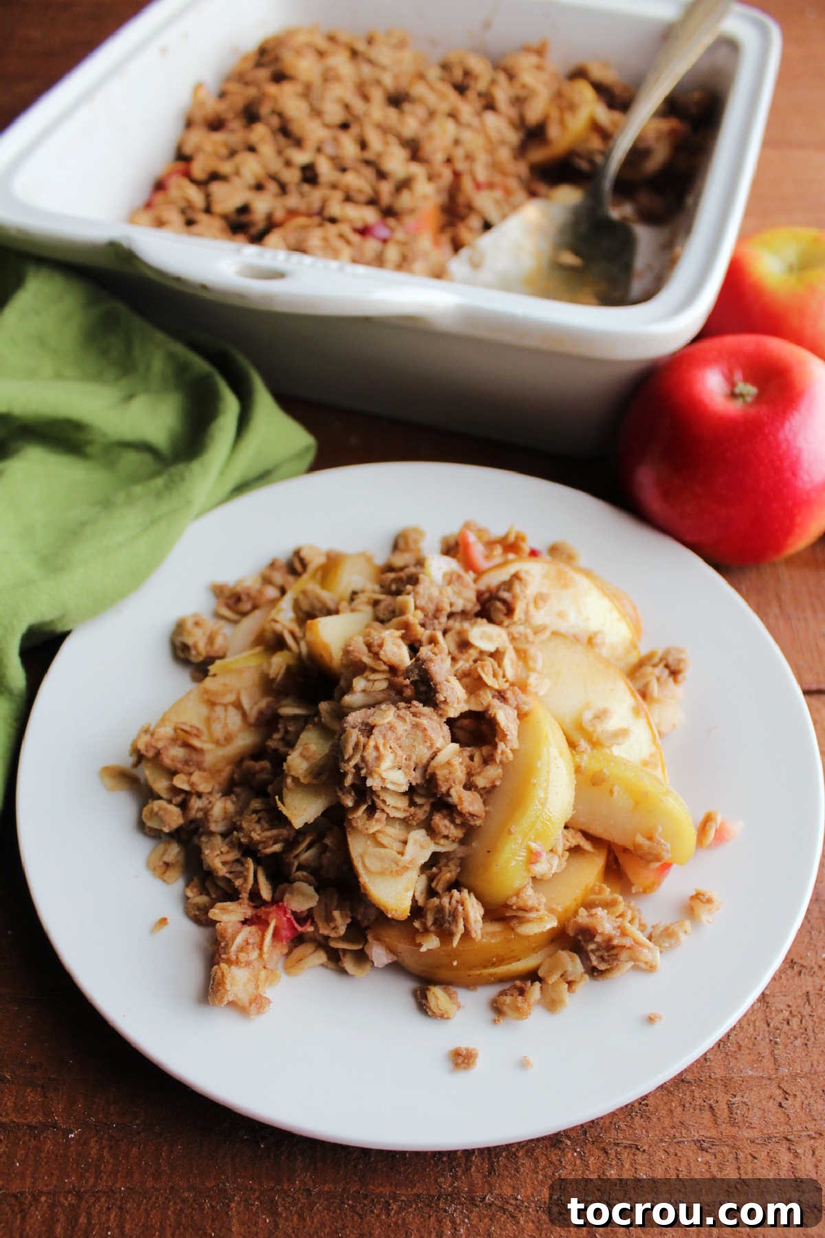 Plate of old fashioned apple crisp with perfectly sliced apples and a crispy buttery oat topping, ready to eat.