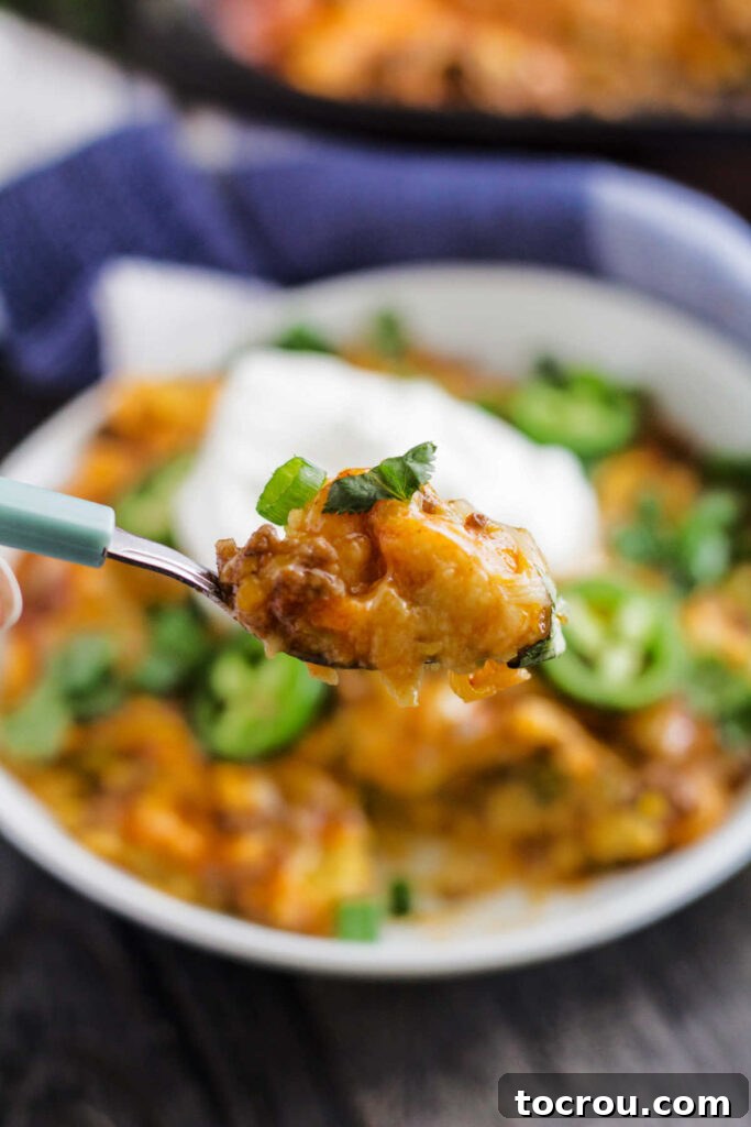 Bite of easy tamale casserole on fork, ready to eat.