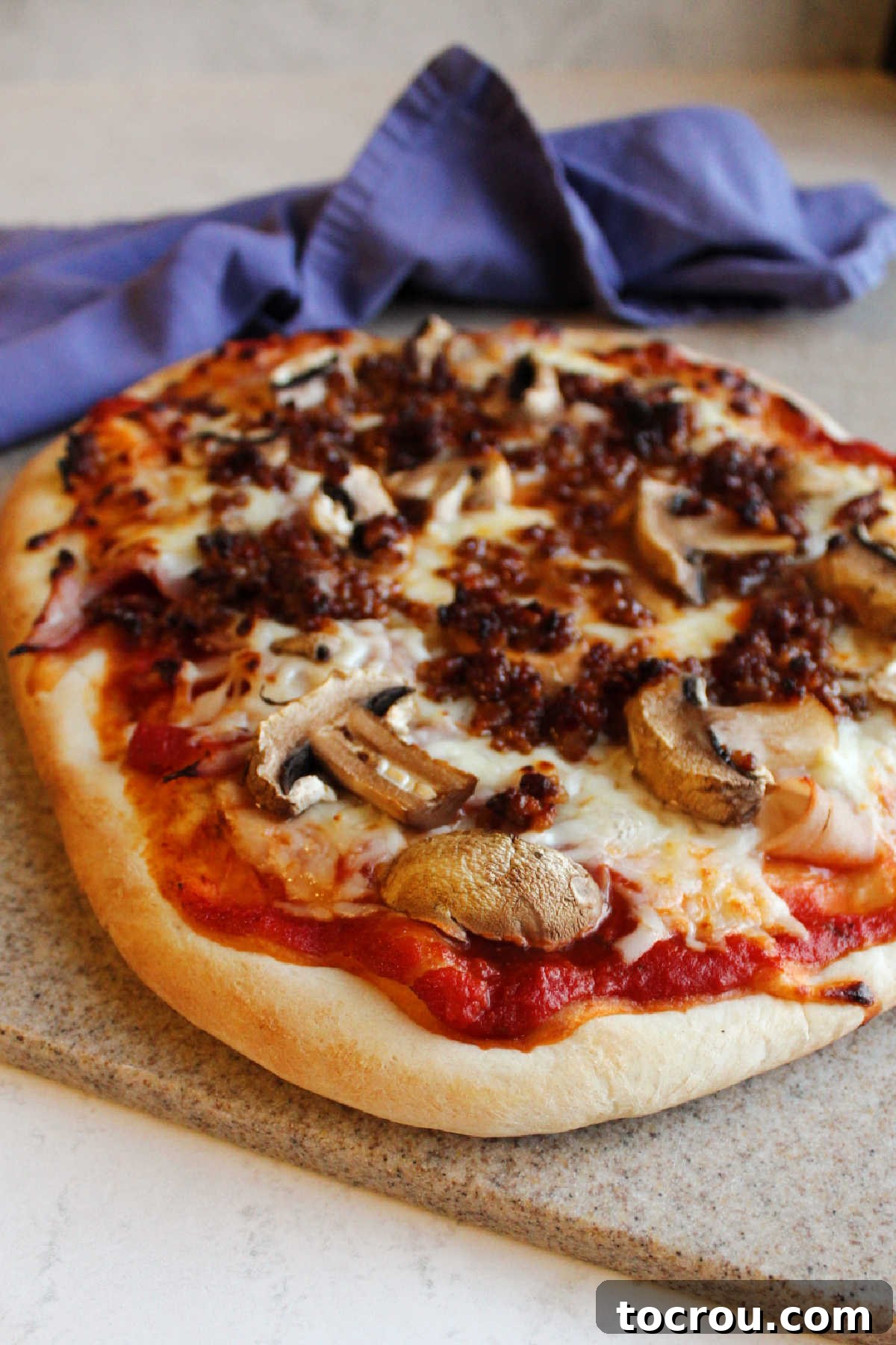 Delicious Sourdough Pizza Cooked pizza with sourdough crust topped with sauce, cheese, mushrooms, sausage and ham.