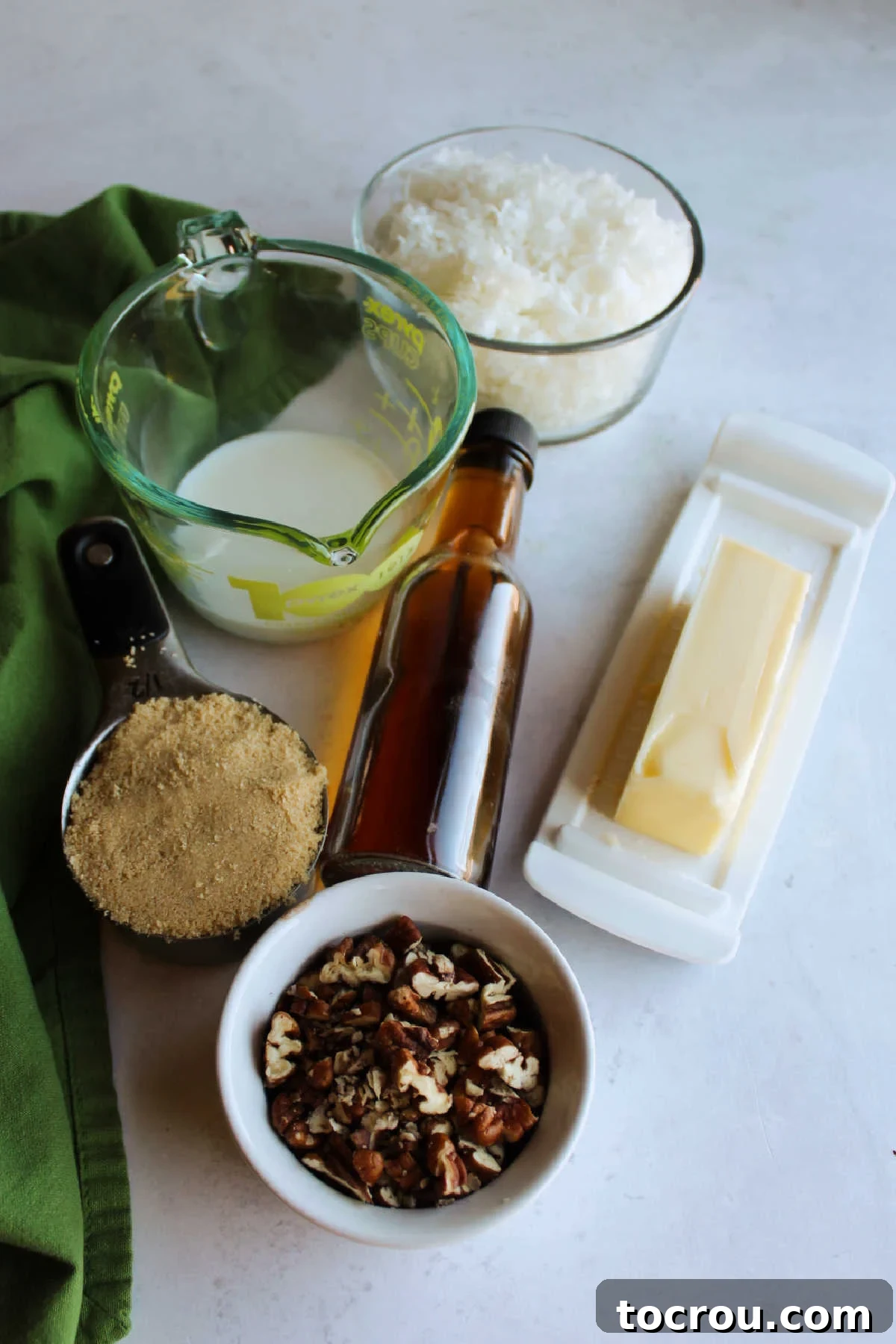 Decadent German Chocolate Cake Crowned with Broiled Coconut 6 Close-up of ingredients for the broiled coconut cake topping, including shredded coconut, chopped pecans, brown sugar, butter, and milk.