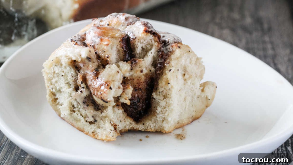 Bite of Coffee Cinnamon Roll Soft coffee and cream cinnamon roll on plate with bite missing showing coffee and cinnamon filling.
