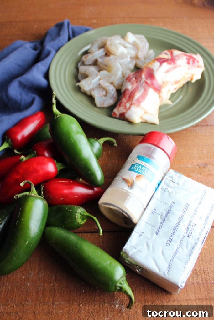 Ingredients including raw shrimp and bacon, jalapenos, cream cheese, and garlic powder ready to be made into shrimp stuffed jalapenos. 
