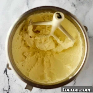 Mixer bowl with lots of cream cheese frosting for the cake.