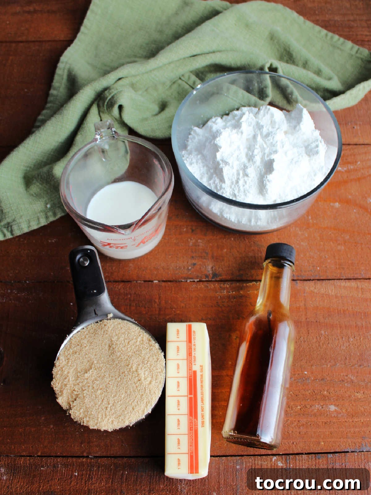 Pantry staples for an amazing frosting Icing ingredients including butter, brown sugar, milk, vanilla, and powdered sugar ready to get made into penuche icing.