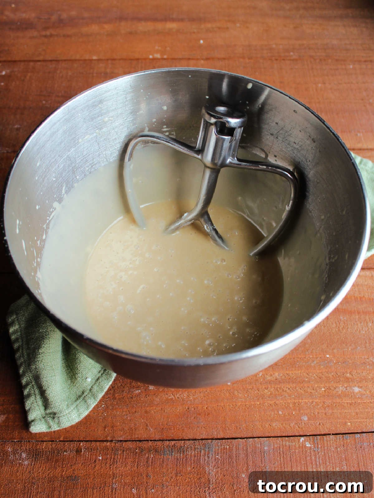 Whipping to perfection Mixer bowl with brown sugar mixture combined with vanilla and powdered sugar to make an icing, showing the whipping process.