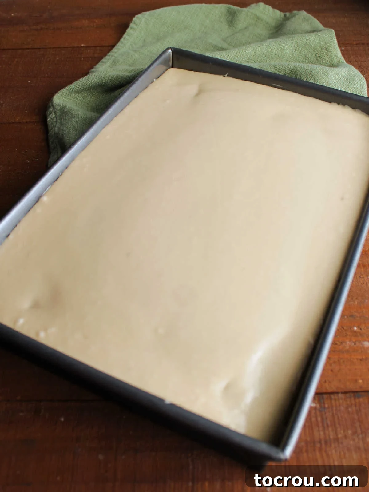 Perfectly spread icing Smooth butterscotch icing spread evenly over a cake in a 9x13-inch pan, ready for serving.