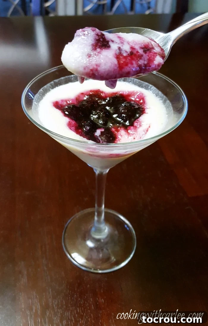 This simple dessert is perfect for al fresco dining. It is elegant enough for a dinner party and simple enough for just because. If you haven't tried cornmeal pudding yet, you really should! A spoon lifting a delicious spoonful of creamy cornmeal pudding, generously coated with a rich, dark blueberry sauce.