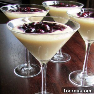Martini glasses filled with cornmeal budino (pudding) and topped with a blueberry marmellata sauce.