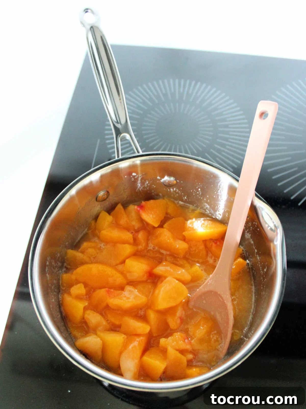 Peaches in Saucepan Chopped peaches, sugar, and lemon juice combined in a saucepan, ready to be simmered into a delightful peach sauce.