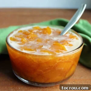 Glass bowl filled with homemade peach sauce ready to go on ice cream, pancakes, waffles and more.