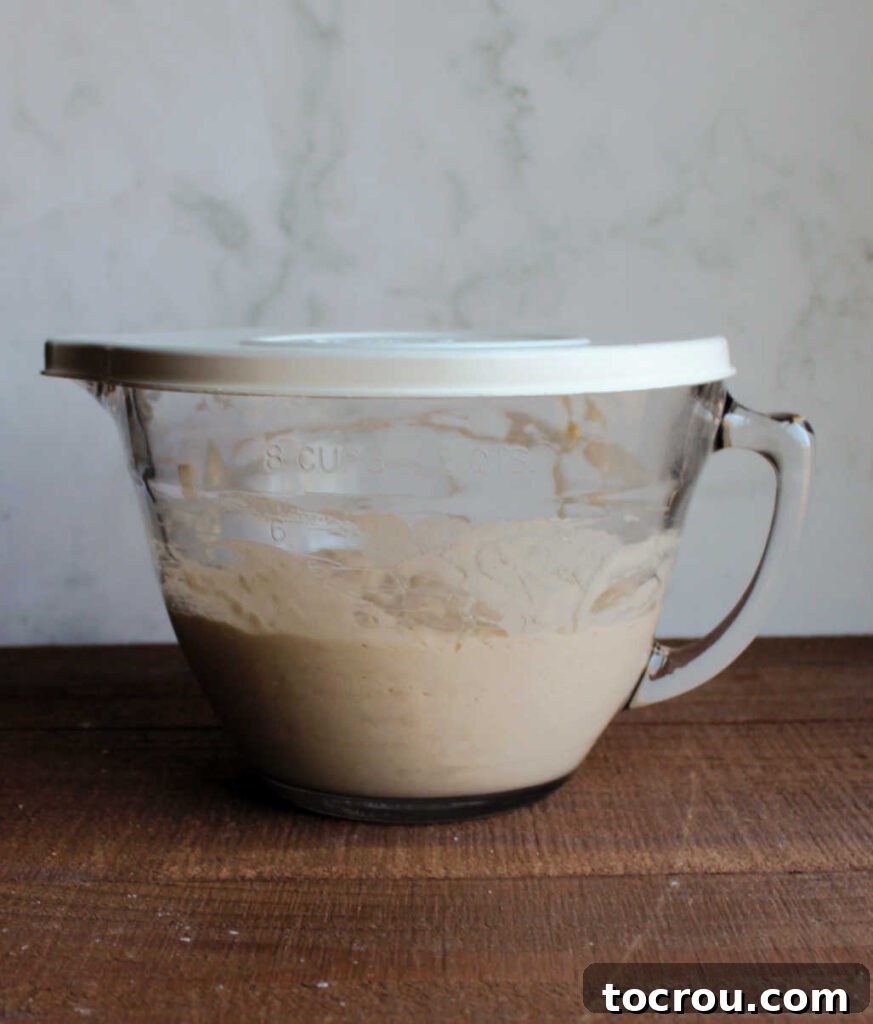 Glass batter bowl with sourdough sponge inside ready to be made into waffles.